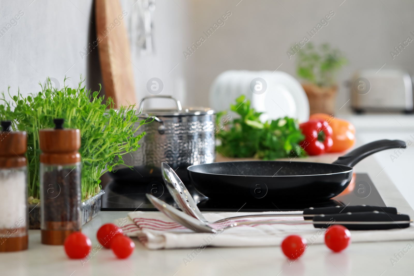 Photo of Countertop with different cooking utensils and vegetables in kitchen