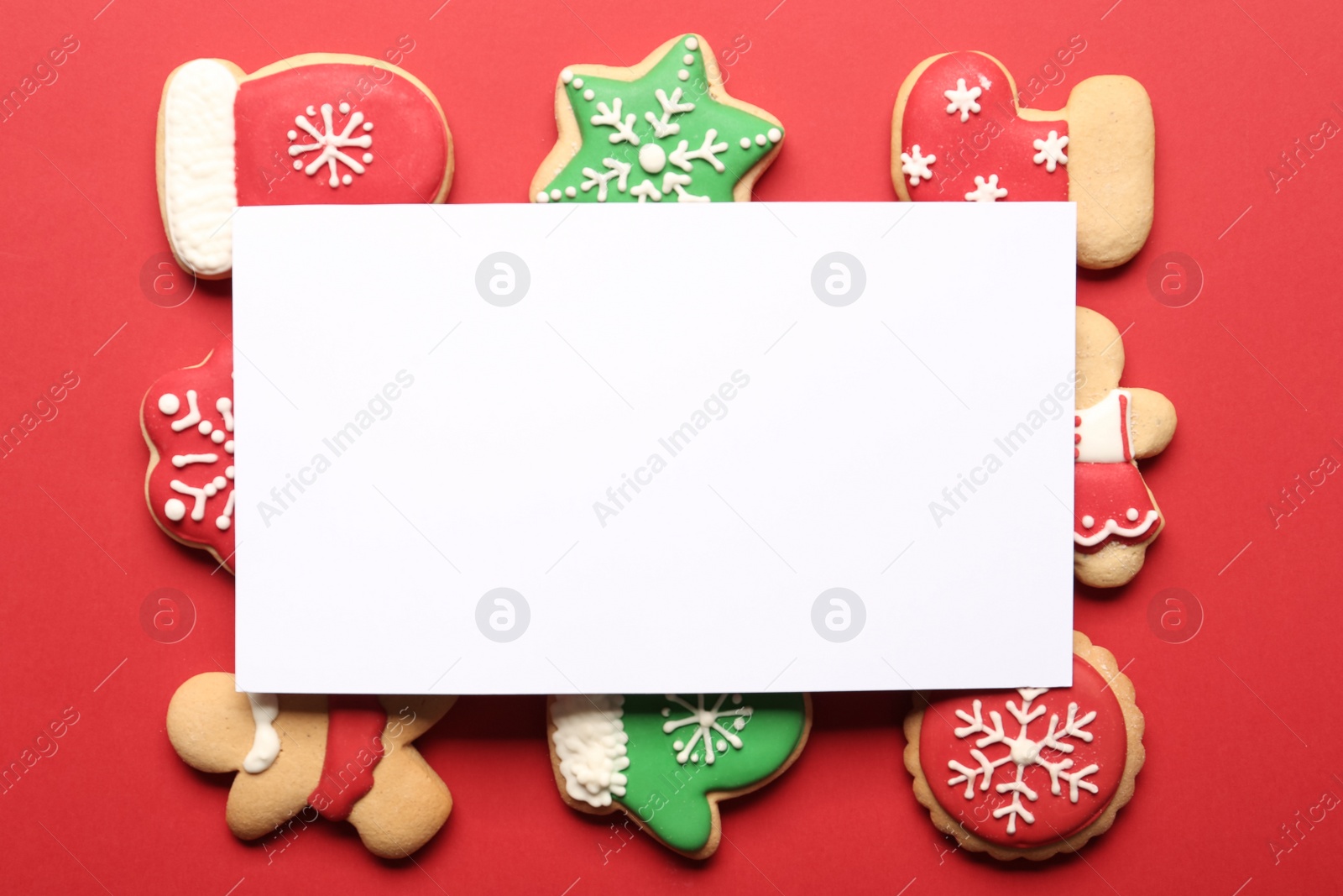 Photo of Flat lay composition with tasty homemade Christmas cookies and blank card on red background. Space for text