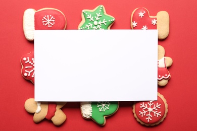 Photo of Flat lay composition with tasty homemade Christmas cookies and blank card on red background. Space for text