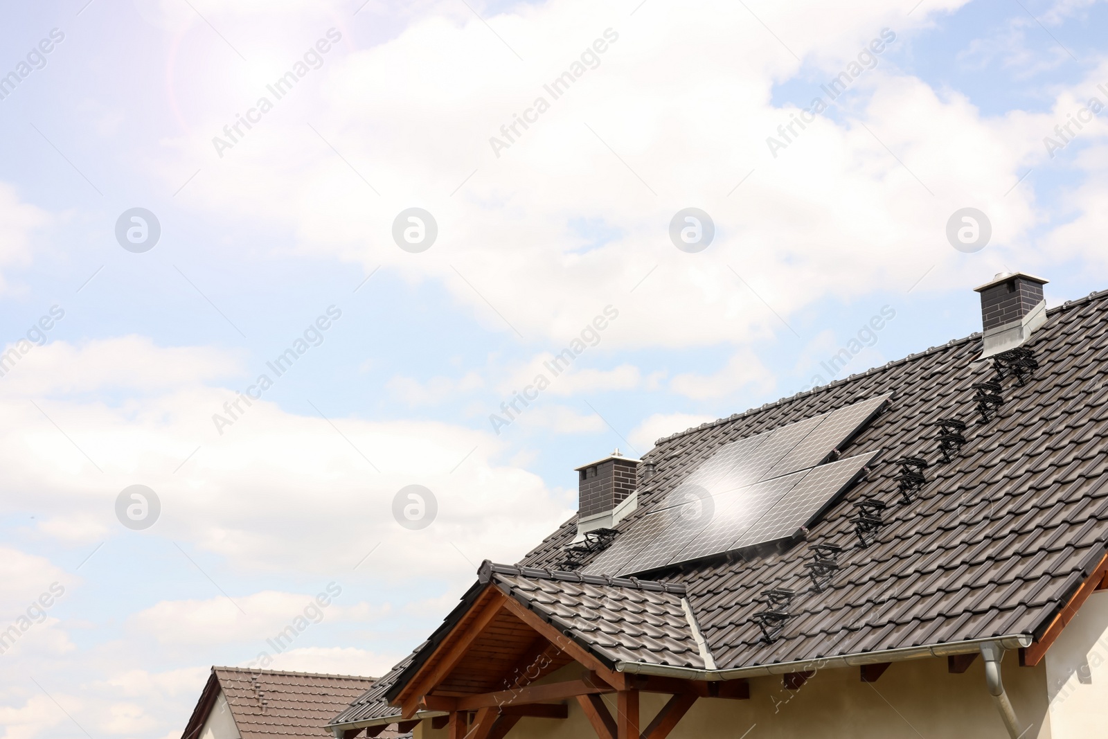 Photo of House with installed solar panels on roof, space for text. Alternative energy