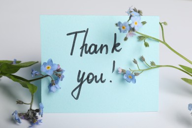 Photo of Card with phrase Thank You and beautiful forget-me-not flowers on white background, closeup