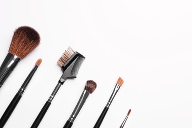 Photo of Set of makeup brushes on white background, flat lay. Space for text