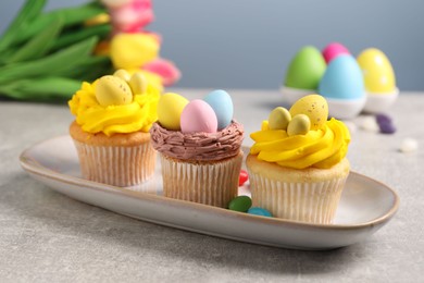 Photo of Tasty decorated Easter cupcakes on grey table