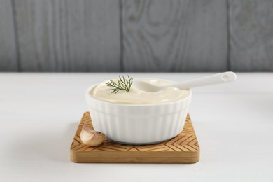 Photo of Fresh mayonnaise sauce in bowl on white wooden table