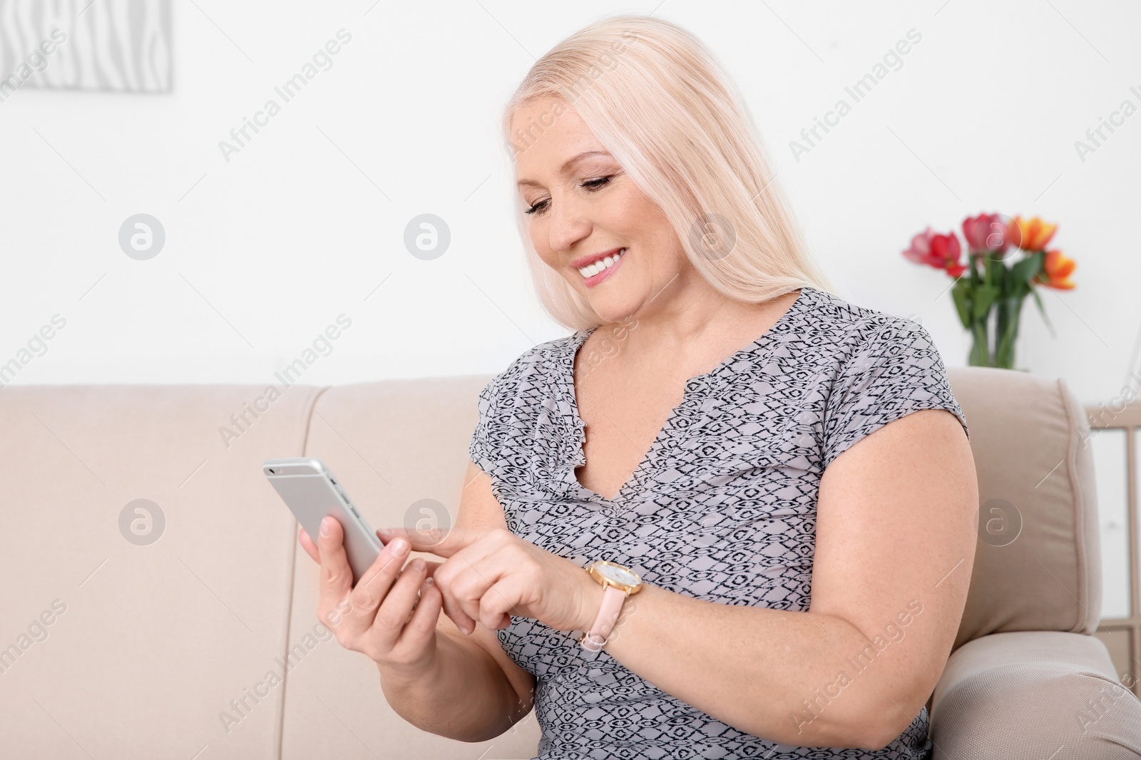 Photo of Mature woman using mobile phone at home