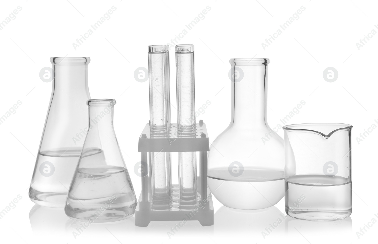 Photo of Laboratory glassware with transparent liquid on white background