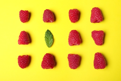 Photo of Flat lay composition with delicious ripe raspberries on yellow background