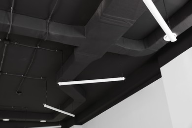 Photo of Black ceiling with lighting in office room