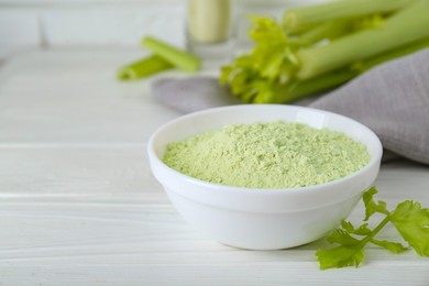 Photo of Natural celery powder in bowl and fresh stalks on white table, closeup. Space for text