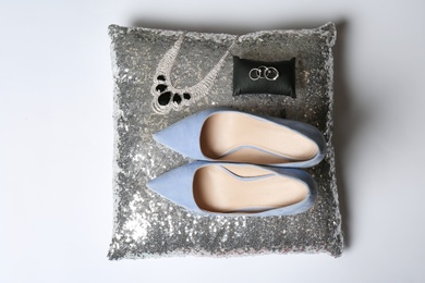 Photo of Pillow with lady's shoes and jewelry on light background, top view