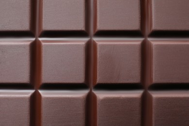 Delicious dark chocolate bar as background, top view