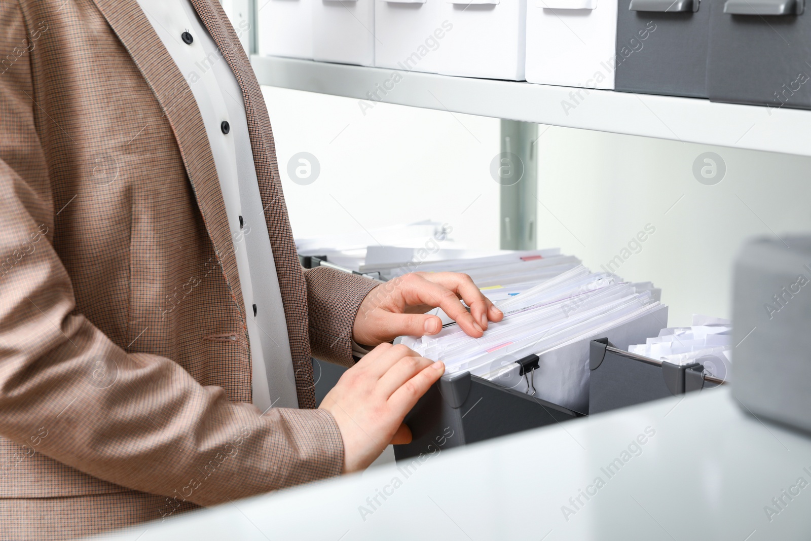 Photo of Woman taking documents from folder in archive, closeup