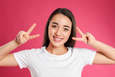 Photo of Woman showing number four with her hands on pink background