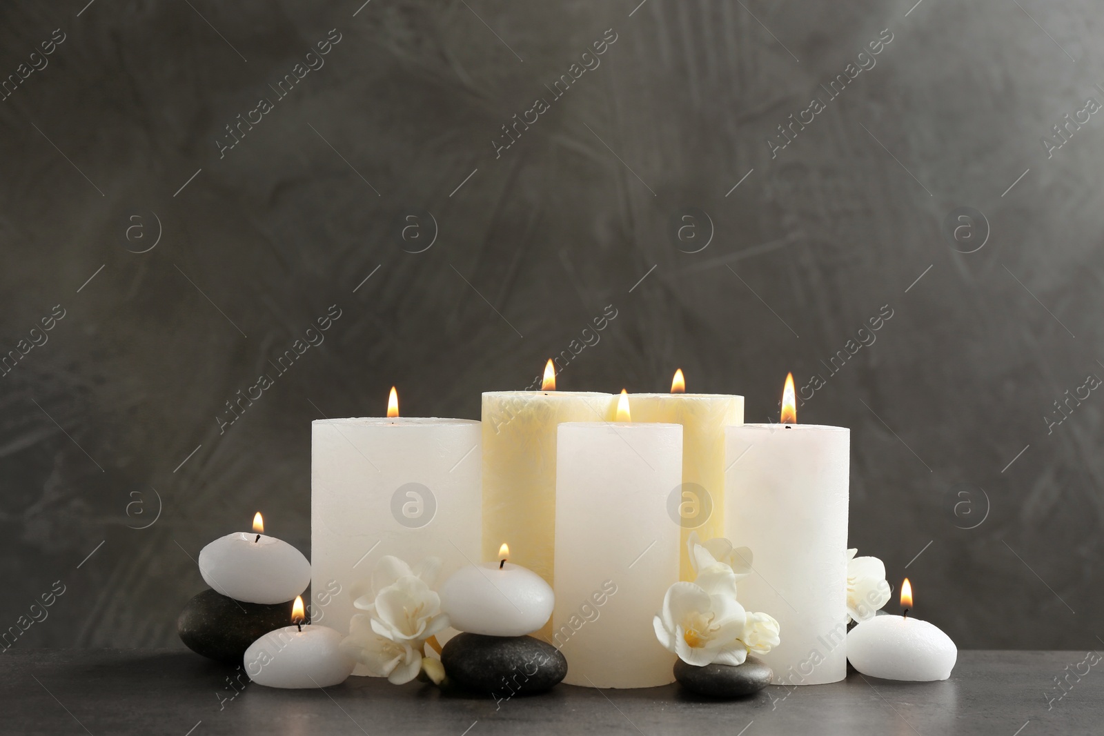 Photo of Beautiful composition with lit candles and flowers on table