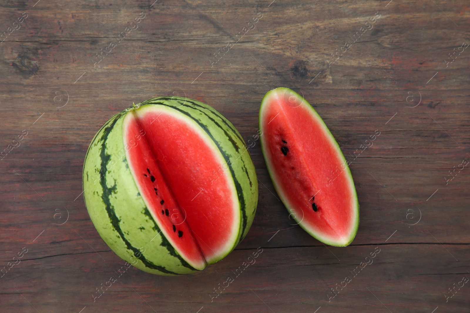 Photo of Cut delicious ripe watermelon on wooden table, top view