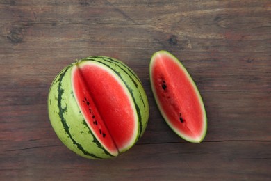 Photo of Cut delicious ripe watermelon on wooden table, top view