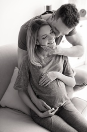 Photo of Young pregnant woman with husband at home, black and white effect