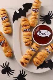 Flat lay composition with tasty sausage mummies for Halloween party on white marble table