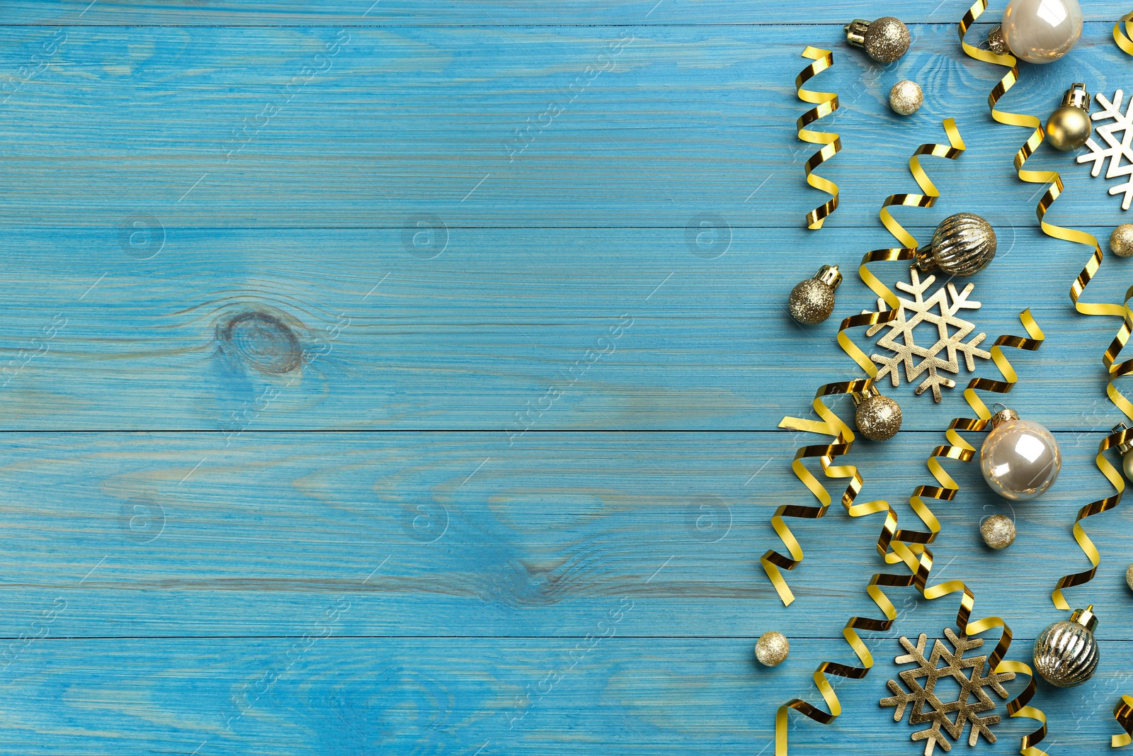 Photo of Flat lay composition with serpentine streamers and Christmas decor on blue background. Space for text