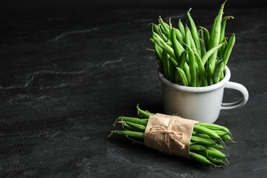 Delicious fresh green beans on black table, space for text