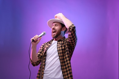 Emotional man with microphone singing in neon lights