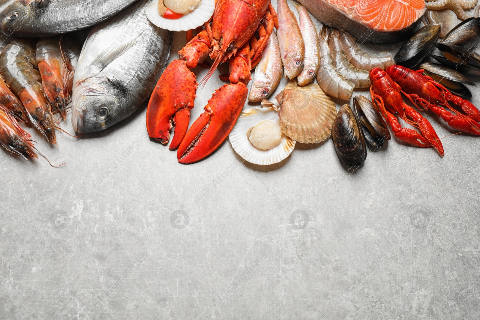 Photo of Fresh fish and seafood on marble table, flat lay. Space for text