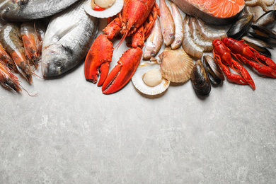 Fresh fish and seafood on marble table, flat lay. Space for text