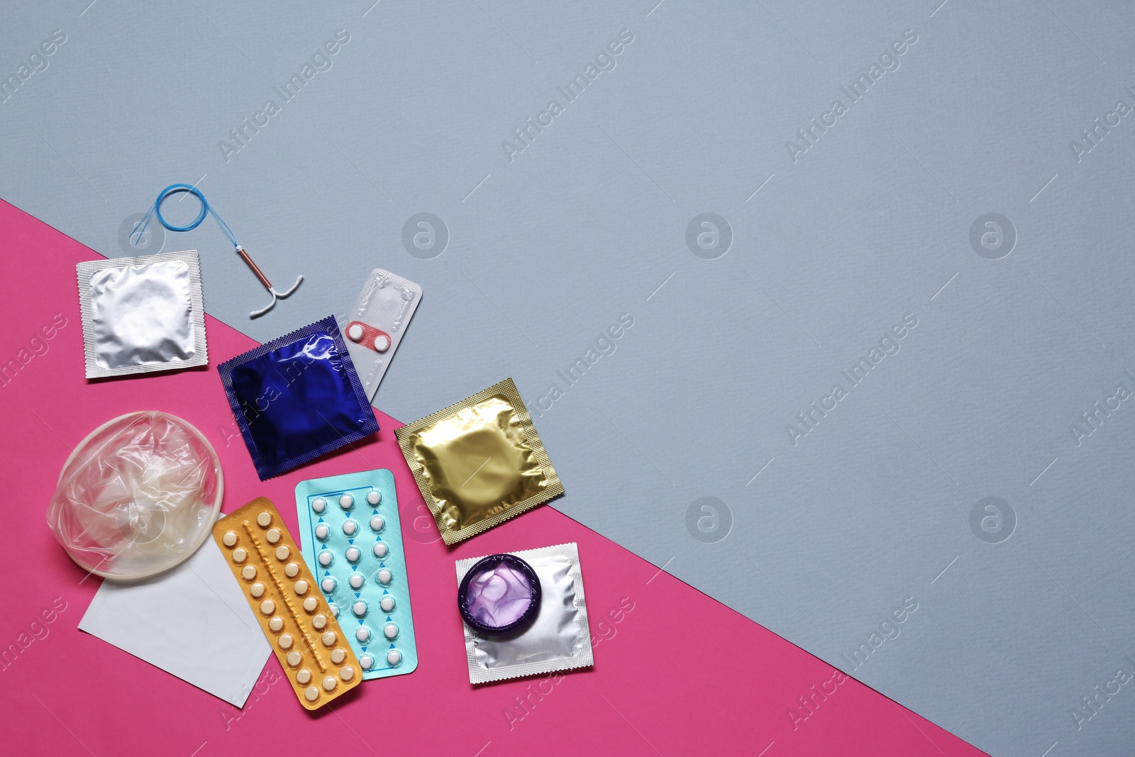 Photo of Contraceptive pills, condoms and intrauterine device on color background, flat lay with space for text. Different birth control methods