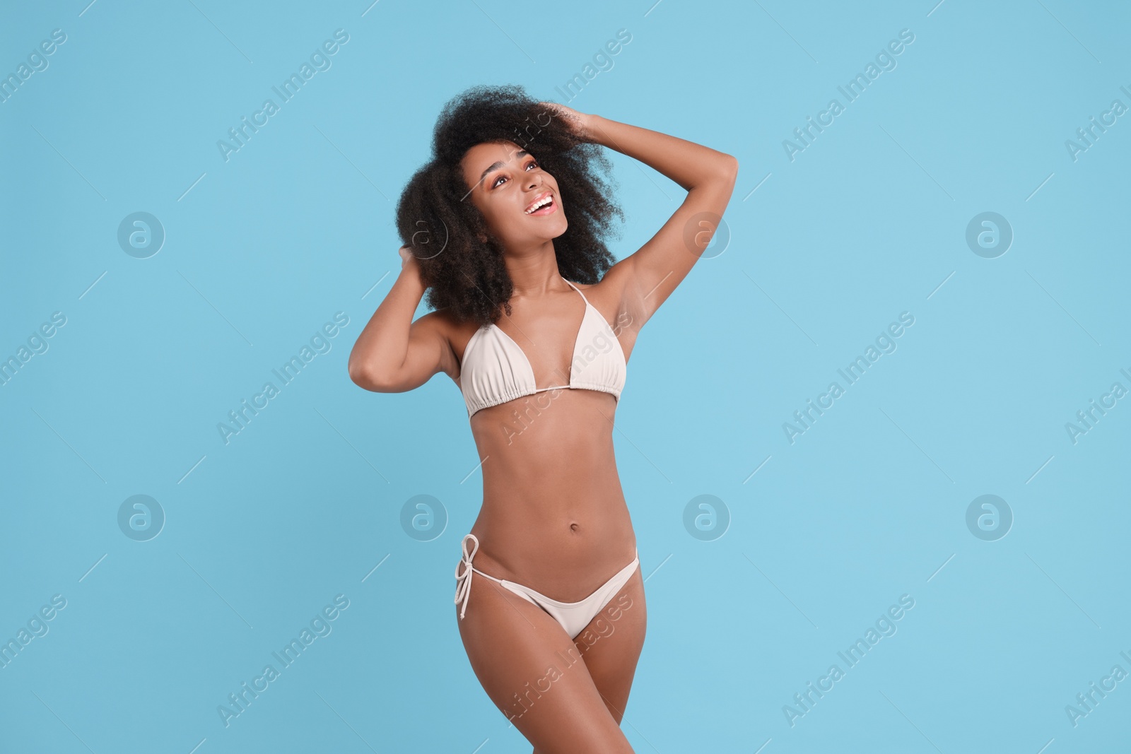 Photo of Beautiful woman in stylish bikini on light blue background