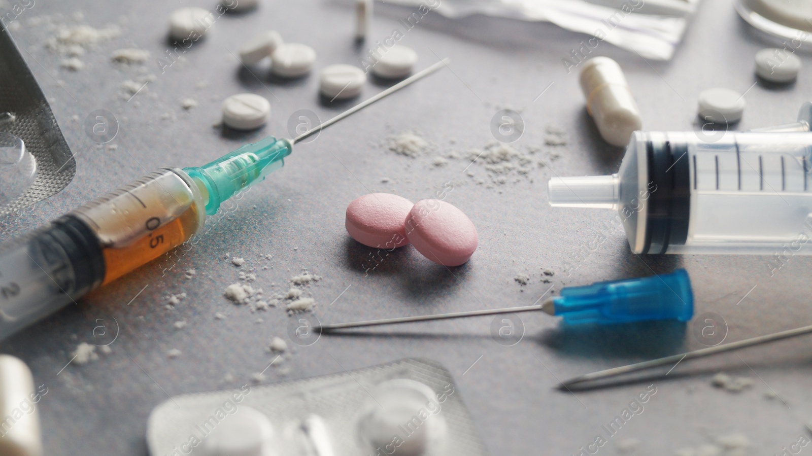 Photo of Different hard drugs on light grey table, closeup