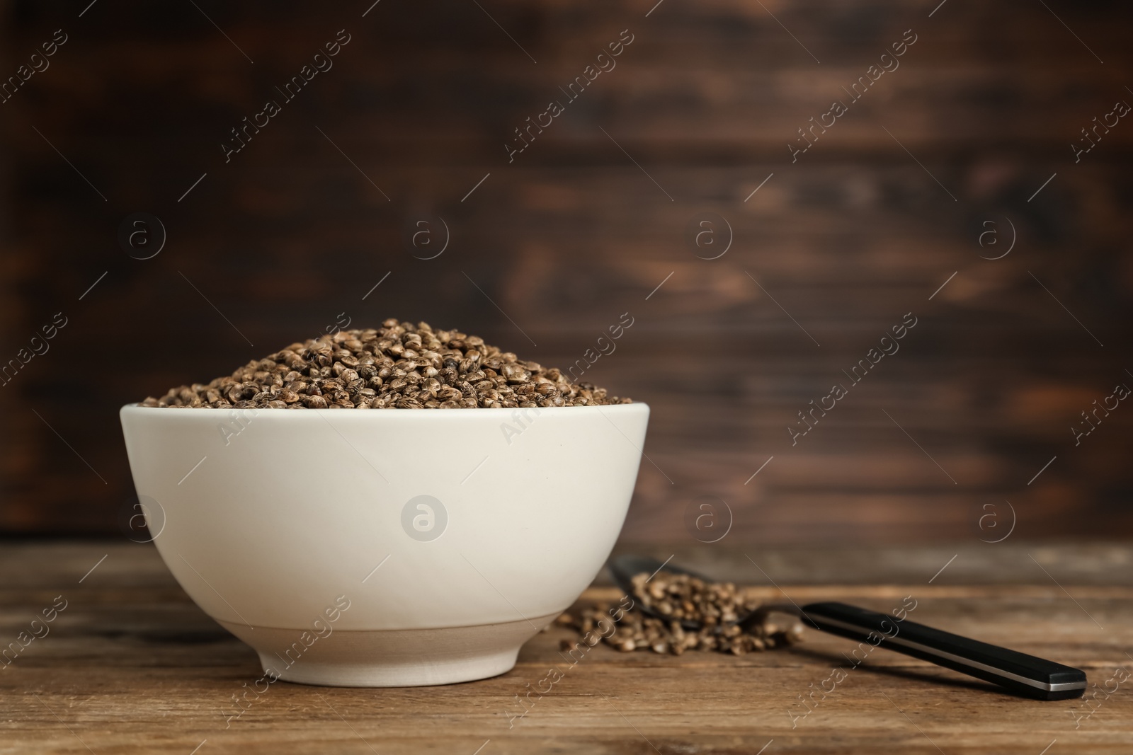 Photo of Ceramic bowl with chia seeds on wooden table, space for text. Cooking utensils