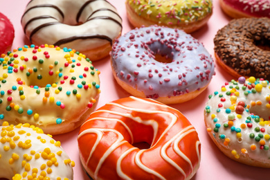 Photo of Delicious glazed donuts on pink background, closeup
