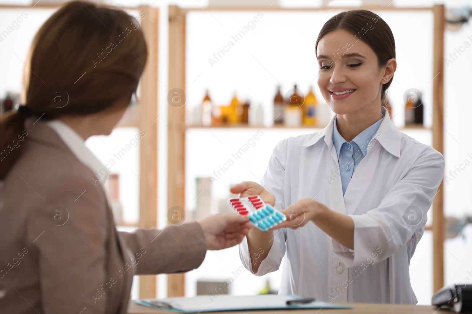 Photo of Pharmacist giving medicine to customer in drugstore