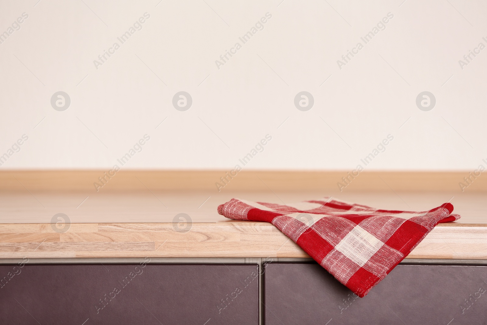 Photo of Fabric checkered towel on wooden table in kitchen