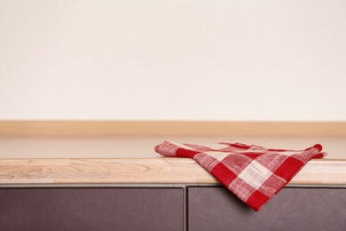 Fabric checkered towel on wooden table in kitchen