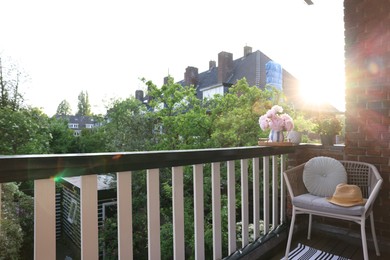 Different plants on railings and chair at cozy balcony outdoors