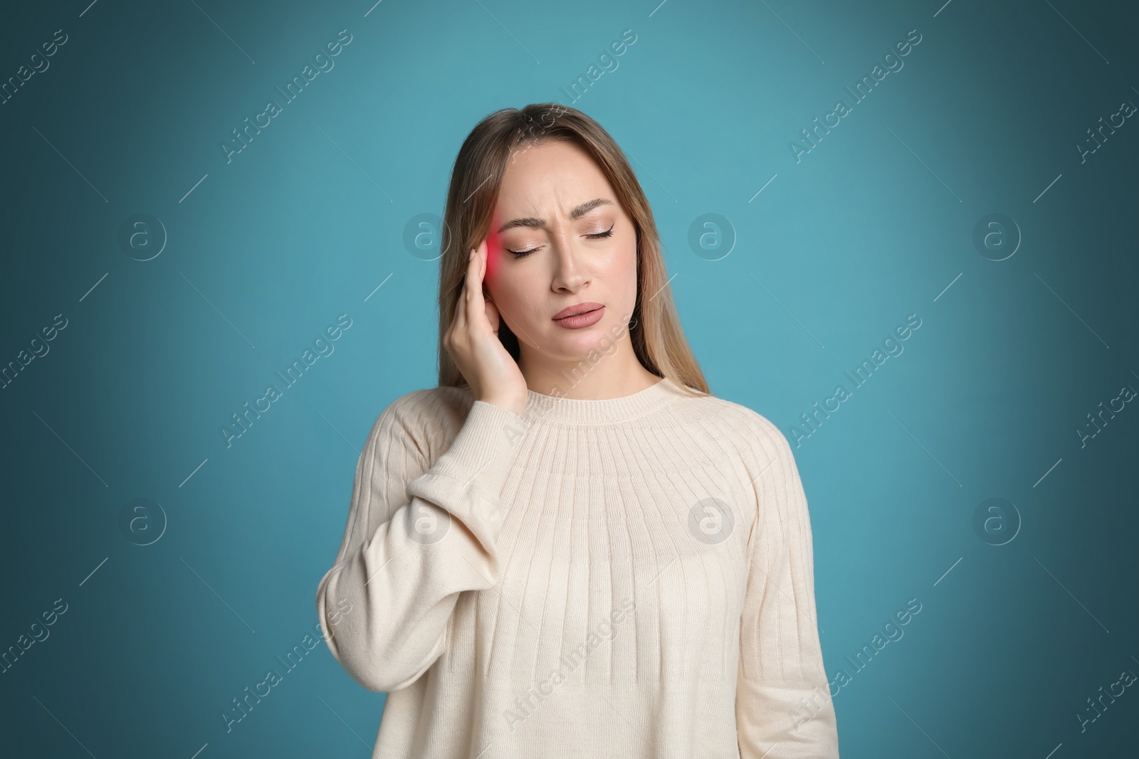 Image of Young woman having headache on light blue background 