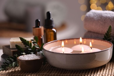 Photo of Beautiful composition with different spa products on table against blurred lights, closeup