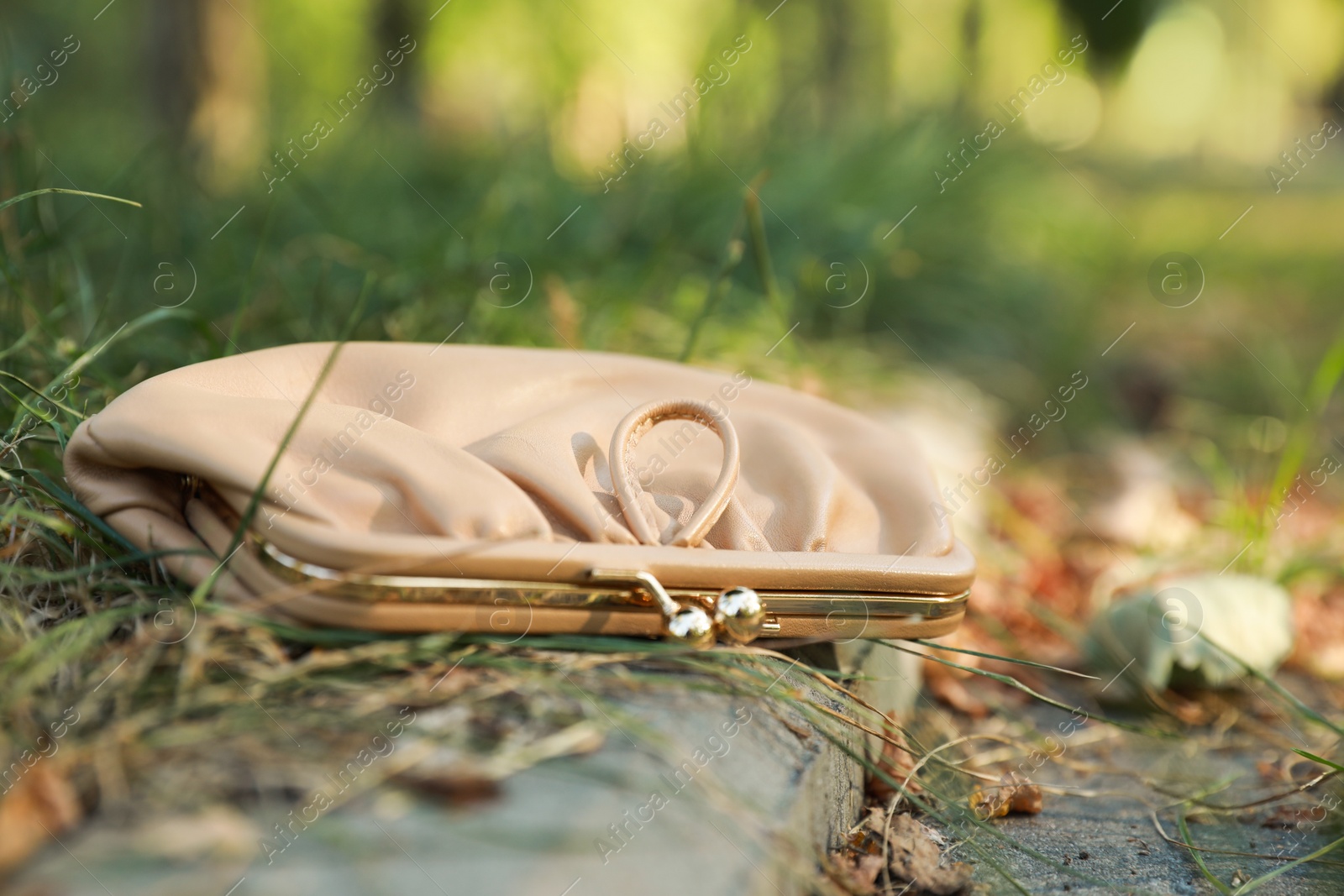 Photo of Beige leather purse outdoors, closeup. Lost and found