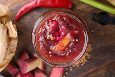 Tasty rhubarb sauce on wooden table, top view