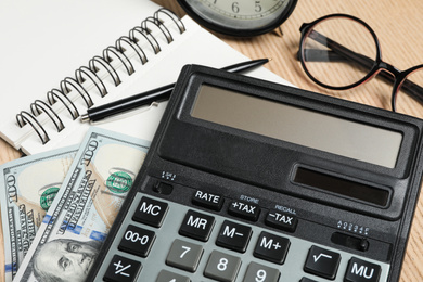 Photo of Calculator, money and stationery on table, closeup. Tax accounting