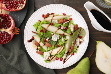 Photo of Delicious pear salad with sauce on wooden table, flat lay