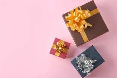 Photo of Flat lay composition with beautiful gift boxes on pink background. Space for text