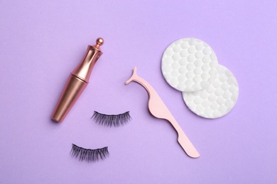 Photo of Flat lay composition with magnetic eyelashes and accessories on violet background