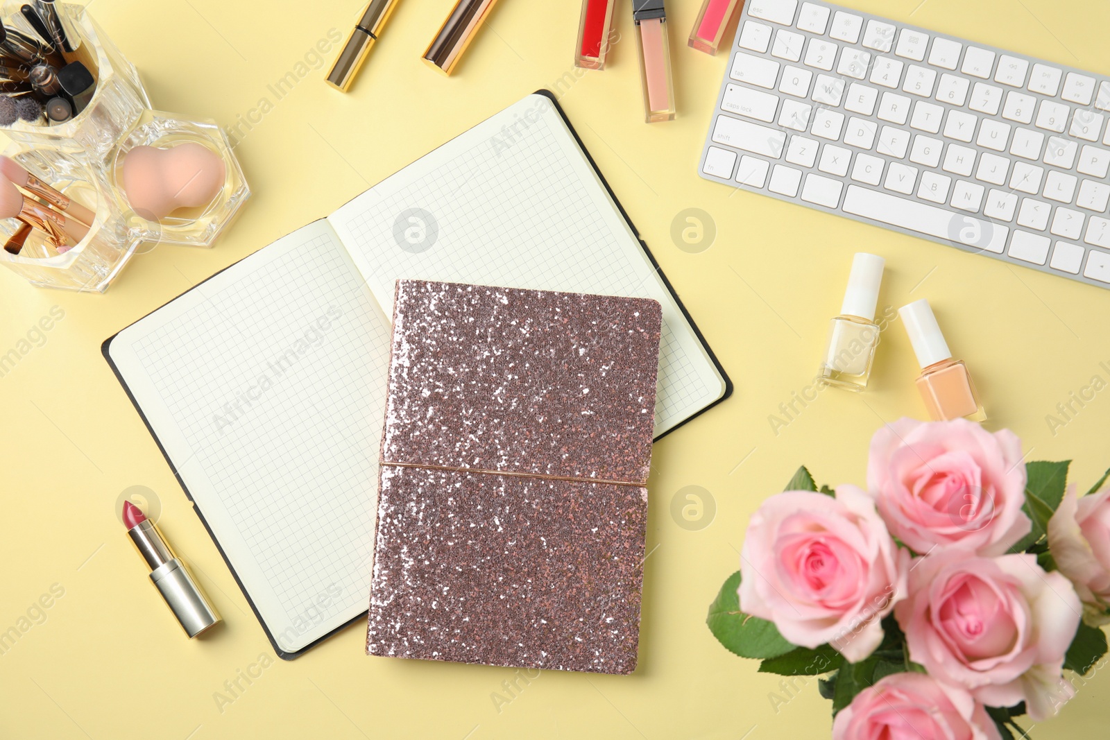 Photo of Blogger's workplace with notebooks, keyboard and cosmetics on color background, flat lay