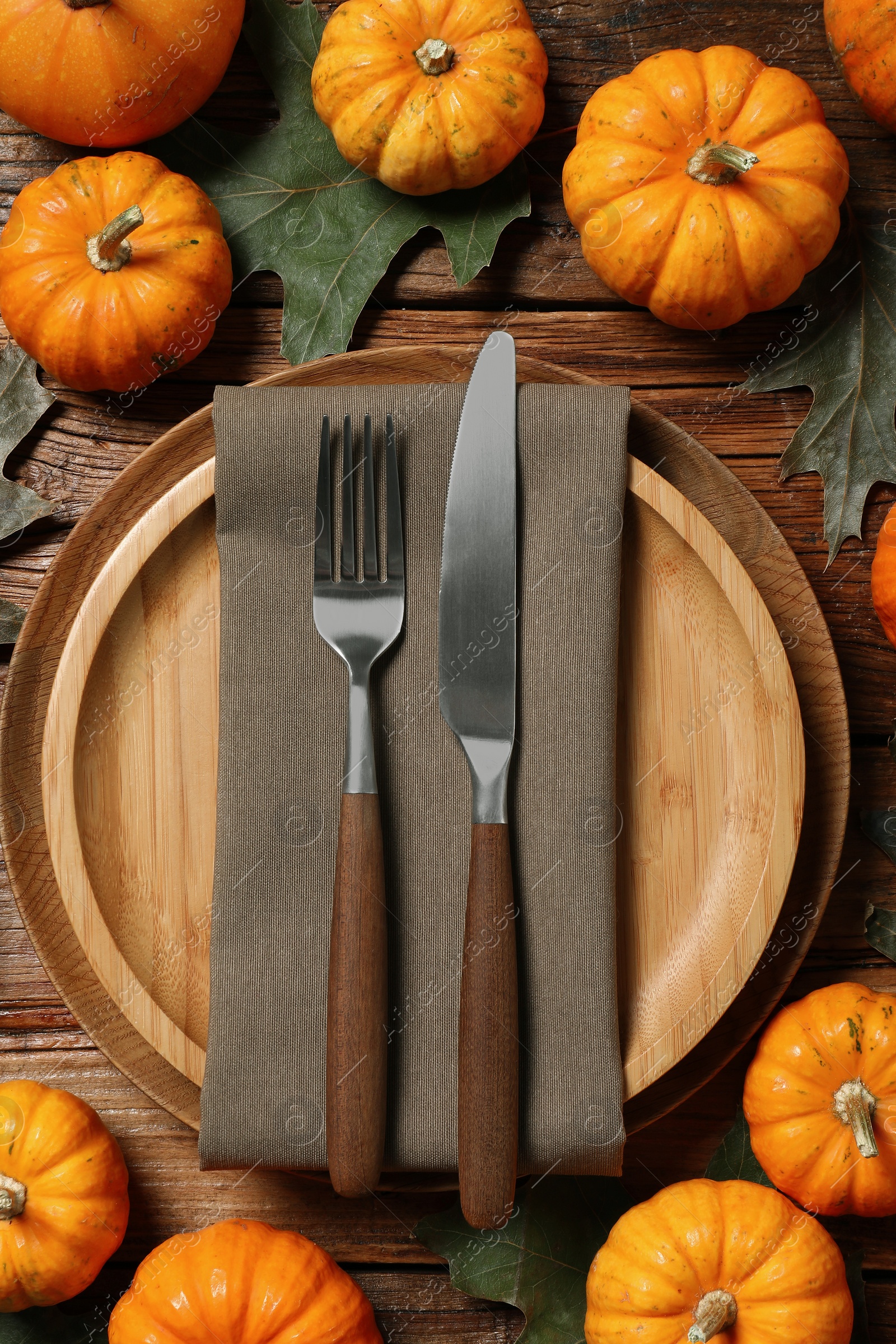 Photo of Happy Thanksgiving day. Autumn table setting, pumpkins and dry leaves on wooden background, flat lay