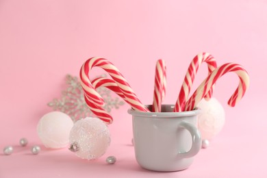 Photo of Candy canes and Christmas balls on pink background