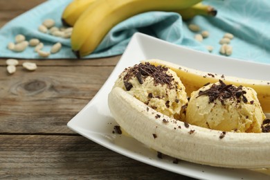 Photo of Delicious banana split ice cream on wooden table, closeup