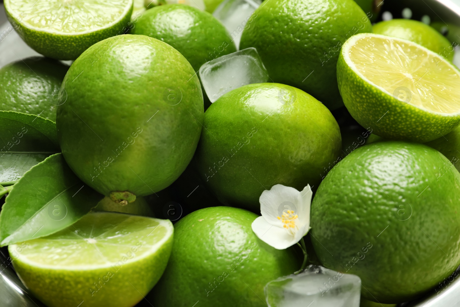 Photo of Fresh ripe limes and ice cubes, closeup