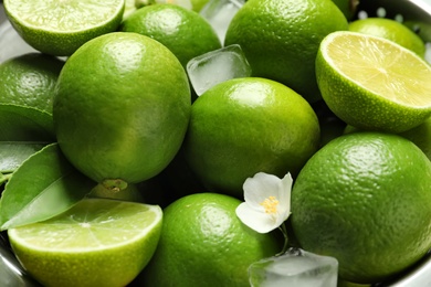 Fresh ripe limes and ice cubes, closeup